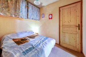 a small bedroom with a bed and a door at Appartement montagnard à Bolquère, 57m², vue montagne, balcon in Bolquere Pyrenees 2000