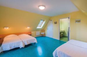 two beds in a room with yellow walls at Grande maison conviviale à Saint-Côme-d'Olt avec jardin et cheminée in Saint-Côme-dʼOlt +17 photos