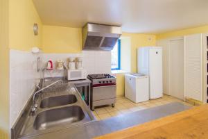 a kitchen with a stainless steel sink and a refrigerator at Grande maison conviviale à Saint-Côme-d'Olt avec jardin et cheminée in Saint-Côme-dʼOlt