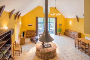 a large living room with yellow walls and a table at Grande maison conviviale à Saint-Côme-d'Olt avec jardin et cheminée in Saint-Côme-dʼOlt
