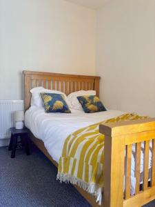a bedroom with a wooden bed with two pillows at Maple, 3 Double Beds, Contractors Welcome in Abertillery