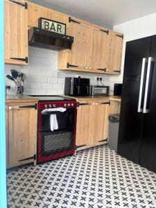 a kitchen with a red stove and a black refrigerator at Maple, 3 Double Beds, Contractors Welcome in Abertillery