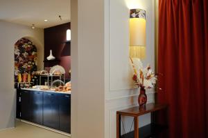 a kitchen with a red curtain and a table with flowers at Hôtel Mayflower Opera in Paris