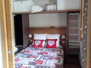 a bedroom with a bed with two red pillows at Appartement cosy à Pelinche, Risoul - 30m² in Risoul