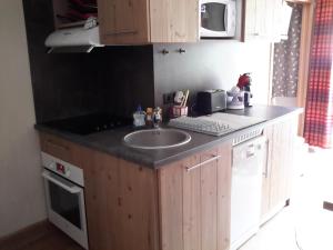 a kitchen with a sink and a microwave at Appartement cosy à Pelinche, Risoul - 30m² in Risoul