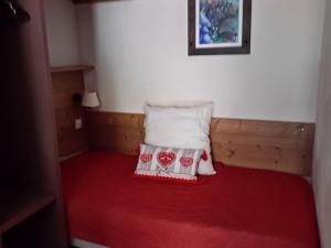 a small bed with a pillow and a red blanket at Appartement cosy à Pelinche, Risoul - 30m² in Risoul +22 photos