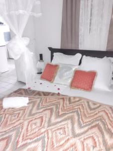 a bed with two pillows on it in a bedroom at Bungalow cosy à Sainte-Rose, piscine et vue sur jardin. in Sainte-Rose