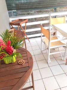 a balcony with a table and chairs and a table at Bungalow cosy à Sainte-Rose, piscine et vue sur jardin. in Sainte-Rose +11 photos