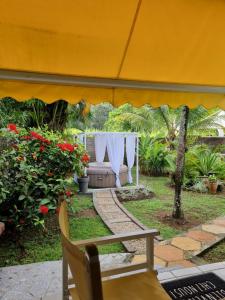 a tent with a table and flowers in a garden at Bungalow cosy à Sainte-Rose, piscine et vue sur jardin. in Sainte-Rose