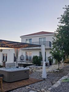 a house with a patio with a bed and an umbrella at Rural home Basin dvor with jacuzzi in Vinišće