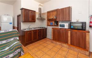 a kitchen with wooden cabinets and a sink and a microwave at Charming House in Montefrío with Private Pool in Montefrío