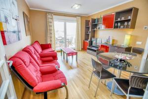 a living room with a red couch and a table at Modern apartment in Roquetas de Mar with sea view in Roquetas de Mar