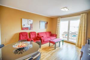 a living room with red furniture and a table at Modern apartment in Roquetas de Mar with sea view in Roquetas de Mar