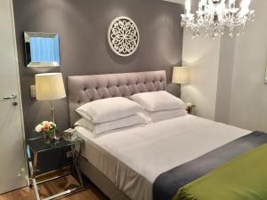 a bedroom with a large bed and a chandelier at Luxury Apartment Tagle with flexible Chek in or Check out in Buenos Aires