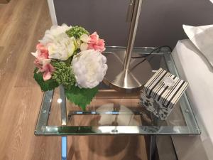 a glass table with a vase of flowers on it at Luxury Apartment Tagle with flexible Chek in or Check out in Buenos Aires +31 photos