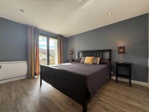 a bedroom with a large bed and a large window at Iduzki-alde bat in Souraïde