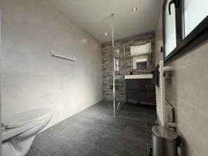 a bathroom with a toilet and a glass shower at Iduzki-alde bat in Souraïde +15 photos