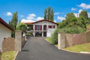 a white house with a driveway at Iduzki-alde bat in Souraïde