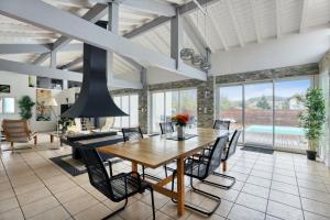 a dining room with a wooden table and chairs at Villa spacieuse à Bidart avec piscine privée 330 m² in Bidart