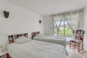 two beds in a room with a window at Villa spacieuse à Bidart avec piscine privée 330 m² in Bidart