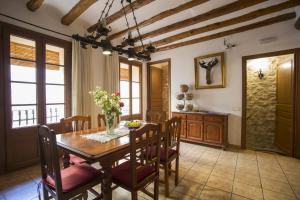 a dining room with a wooden table and chairs at Casa rural la Posada ,Terra Alta, Matarraña. in Caseras