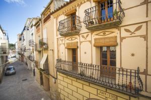 a building with balconies and windows on a street at Casa rural la Posada ,Terra Alta, Matarraña. in Caseras
