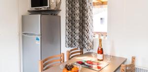 a table with a bottle of wine and a plate of fruit at Bungalow charmant à Onzain avec vue sur jardin in Onzain