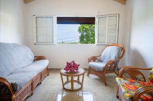 a living room with a couch and chairs and a table at Maison vue sur mer à Vieux-Habitants + Terrasse in Vieux-Habitants