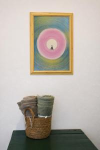 a painting on a wall with a basket on a table at Zen Yoga & Surf House in Arugam Bay