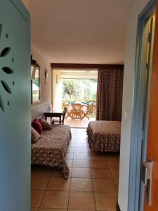 a hotel room with two beds and a balcony at Studio charmant à Sainte-Anne de 25 m² avec terrasse et jardin. in Sainte-Anne