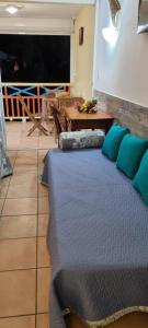 a bedroom with a bed with blue pillows and a table at Studio charmant à Sainte-Anne de 25 m² avec terrasse et jardin. in Sainte-Anne