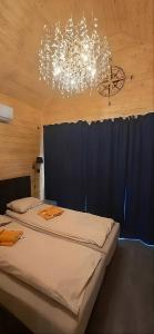 a bedroom with two beds and a chandelier at Domek SPA z sauną i jacuzzi - Level780 in Koszarawa
