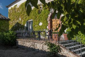 a black fence in front of a building with ivy at Quaint house in Murlo with shared pool in Murlo