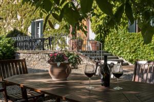 a wooden table with two glasses of wine and a vase at Quaint house in Murlo with shared pool in Murlo +41 photos