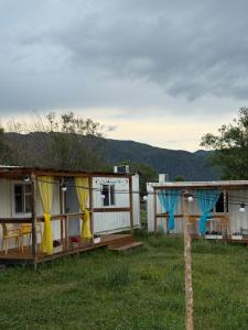 a house with yellow and blue drapes in a yard at Qurmety camp in Kurmenty