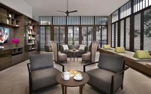 a living room with chairs and a couch and a table at Somerset Park Suanplu Bangkok in Bangkok
