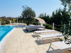 a patio with benches and a swimming pool at Charming Apartment in Nardò with Shared Pool in Nardò