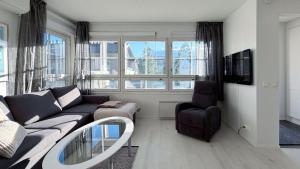 a living room with a couch and a chair at Tahko North Lodge B 5 in Kuopio