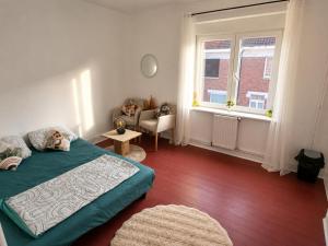 a bedroom with a bed and a chair and a window at Maison Traversière in Long de Bout +5 photos
