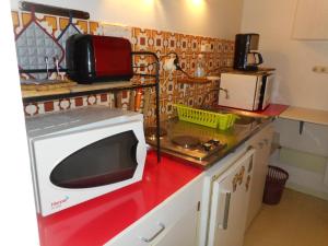 a microwave on a red counter in a kitchen at Studio confortable à Cauterets - 40 m² - Vue sur la montagne in Cauterets +15 photos