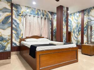 a bedroom with a bed with a painting on the wall at Ankita Guest House Dankuni in Khorel