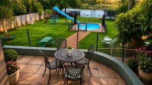 a patio with a table and chairs and a playground at Moonriver Guesthouse in Upington