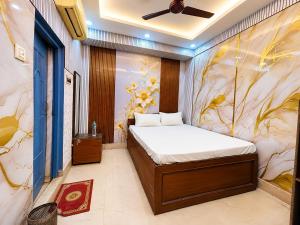 a bedroom with a bed and a flower mural at Ankita Guest House Dankuni in Khorel +10 photos