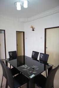 a dining room table with chairs and a butterfly on the wall at Cameron View Apartment @ Crown Imperial Court Brinchang in Cameron Highlands