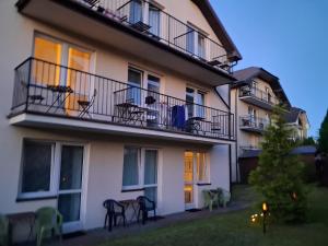 a building with chairs and tables on a balcony at Satori in Władysławowo