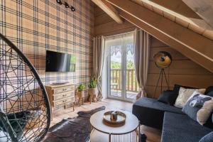 a living room with a couch and a tv at Przytulisko Bieszczady in Smerek