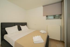 a bedroom with a bed with white sheets and a window at The peaceful escape with shared pool in Porto Rafti +9 photos