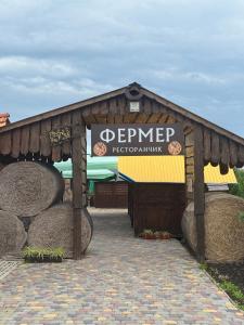 a sign for a store with hay bales at Глинобитні будиночки in Darakhov +9 photos