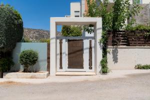 a white door on the side of a building at The peaceful escape with shared pool in Porto Rafti