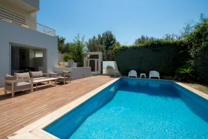a backyard with a swimming pool and a wooden deck at The peaceful escape with shared pool in Porto Rafti